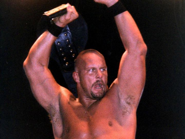Stone Cold Steve Austin in his vest holding the WWF Championship belt